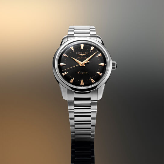 Watch placed on styled background showing black dial and gold hands image number 1